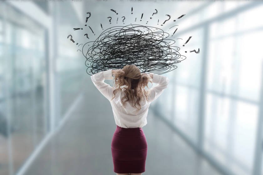 Woman Pulling At Hair in Workplace with Stress And Anger Hanging Over Her Head