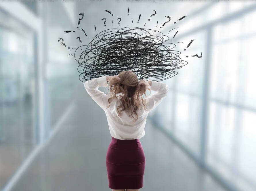 Woman Pulling At Hair in Workplace with Stress And Anger Hanging Over Her Head